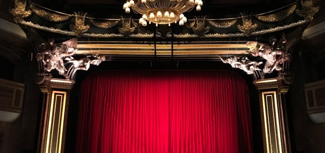Praktfull teaterscen med röd ridå och utsmyckad ljuskrona
